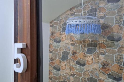 a blue chandelier hanging from a stone wall at In The Heart Of Praia - Family B&B in Praia