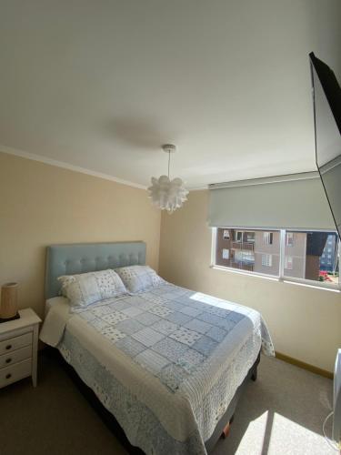 um quarto com uma cama e uma janela em Departamento nuevo y acogedor em Villarrica