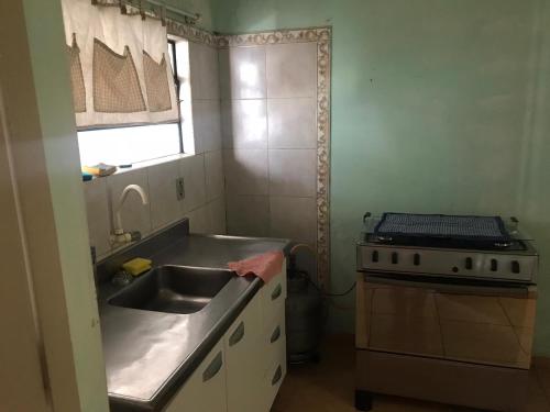 uma cozinha com um lavatório e um fogão em La casa de la abuela em Rivera
