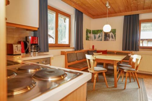 eine Küche und ein Esszimmer mit einem Tisch und Stühlen in der Unterkunft Birkenheim in Sankt Leonhard im Pitztal