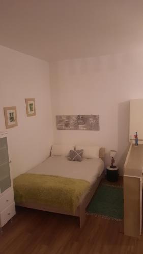 een slaapkamer met een bed met een groene deken bij Le petit nid in Pézenas