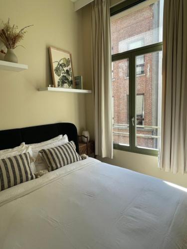 1 dormitorio con cama y ventana grande en Stunning apartment by MAS en Amberes