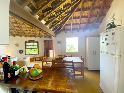 a kitchen and dining room with a table and a refrigerator at Casa del Artista, Ilha Grande Araçatiba in Praia de Araçatiba