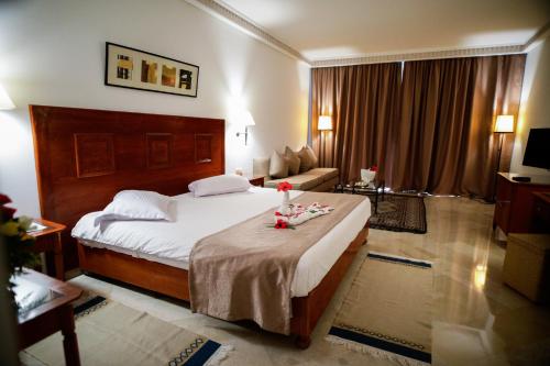 Habitación de hotel con cama y sala de estar. en Alhambra Thalasso en Hammamet