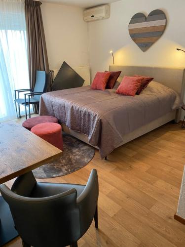 a bedroom with a bed and a table and chairs at Hotelkamer Bellevue in Simpelveld