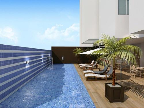una piscina con sillas y palmeras junto a un edificio en Apartamento 2Q Próximo ao Hospital Premium NW1306, en Goiânia