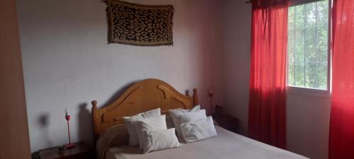 sypialnia z łóżkiem z białymi poduszkami i oknem w obiekcie Maire w mieście Villa Parque Siquiman
