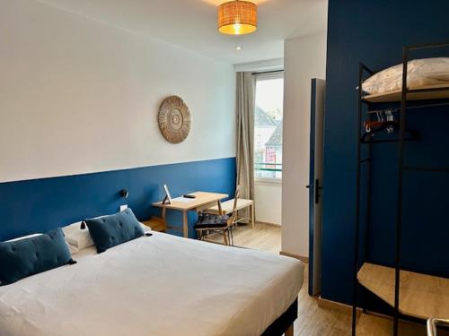 a bedroom with a bed and a table and a desk at Hôtel de la Poste - Piriac-sur-mer in Piriac-sur-Mer