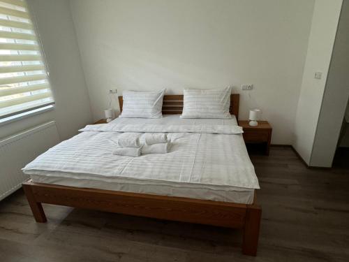 a large white bed with two pillows on it at Wellness & Spa Apartments Lipno - Frymburk in Frymburk