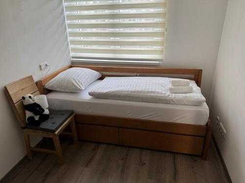 a bed in a room with a window and a chair at Wellness & Spa Apartments Lipno - Frymburk in Frymburk