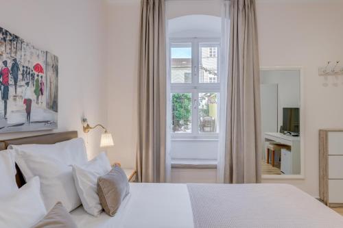 1 dormitorio con cama blanca y ventana en Victoria Luxury Rooms - Split Downtown en Split