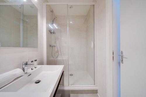 une salle de bain blanche avec une douche et un lavabo dans l'établissement Very lovely apartment Bordeaux, à Bordeaux