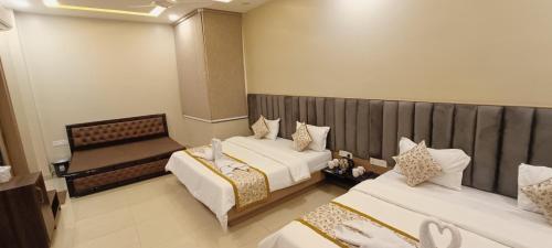 a hotel room with two beds and a mirror at Hotel Madhavam- 250 Mtr from Mathura Railway Station in Mathura