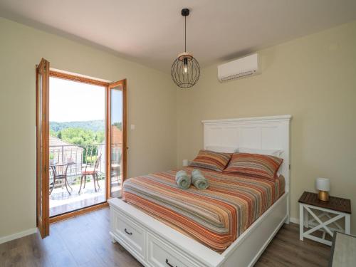 a bedroom with a bed and a balcony at Villa Pero & Jele in Mlini