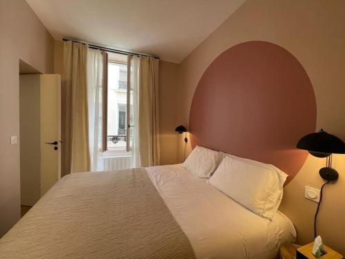 une chambre avec un grand lit et une fenêtre dans l'établissement Marais - Quiet one-bedroom decorated with taste, à Paris