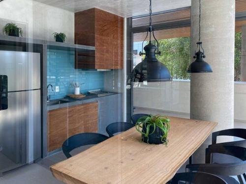 a kitchen with a wooden table with a potted plant at Apt. inteiro recém-reformado - Vila Mariana in São Paulo