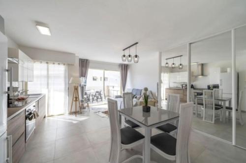 una cucina e un soggiorno con tavolo e sedie di Magnifique studio au pied des plages a Cannes
