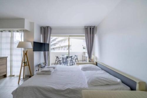 una camera da letto con un letto grande e una finestra di Magnifique studio au pied des plages a Cannes