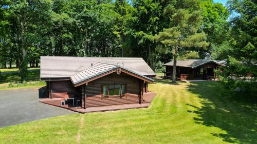 a log cabin in a yard with a house at Pinecroft Lodges in Ingleton 