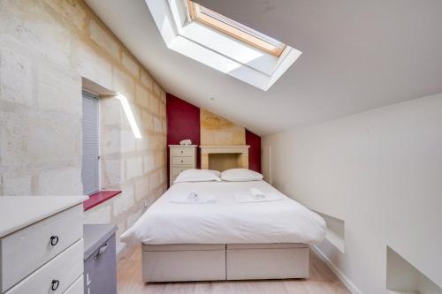 a bedroom with a white bed and a skylight at Charming apartment in the heart of Bordeaux in Bordeaux