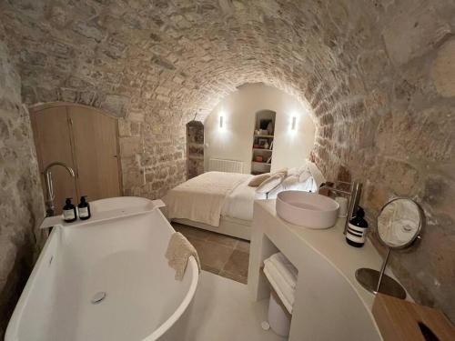 La salle de bains est pourvue d'une baignoire, d'un lit et d'une baignoire. dans l'établissement Marais - Unique duplex decorated with taste, à Paris