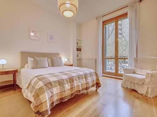 Un dormitorio con una cama y una silla y una ventana. en Apartamento El Cuarto Rey by Clabao, en Pamplona