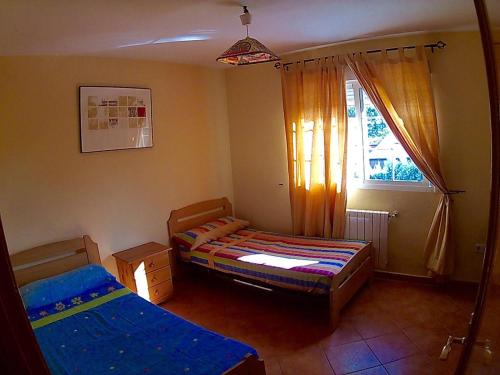 Habitación pequeña con 2 camas y ventana en Villa Pilara en Brunete