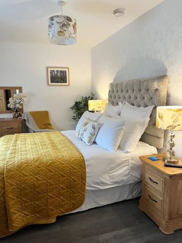1 dormitorio con 1 cama grande con manta amarilla en Thistle cottage 5 star luxury cottage with Hot Tub, en Scarborough