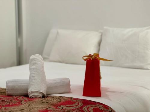 - une pile de serviettes sur un lit avec un cadeau rouge dans l'établissement Cozy Beautiful flat City Center, à Madrid