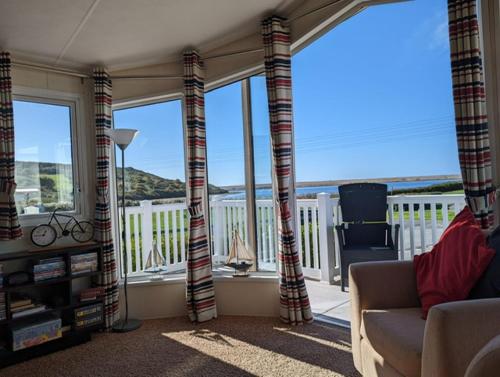 a living room with a view of the ocean at Lovely and Bright Caravan Haven Littlesea with views across the Fleet Lagoon in Weymouth
