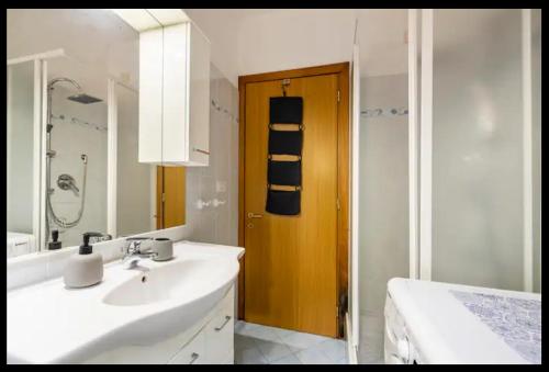 a bathroom with a sink and a wooden door at Palazzo Wanny Free Parking & Terrace in Florence
