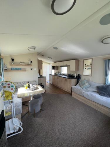 ein Wohnzimmer mit einem Bett und eine Küche in der Unterkunft Seton Sands Holiday Park Klover Karavans in Port Seton