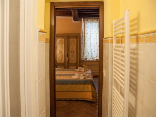 um corredor com um espelho num quarto com uma cama em B&B Il sogno del musicista em Montalcino