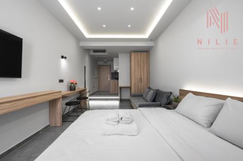 a bedroom with a large white bed and a living room at Pantheon, Nilie Hospitality MGMT in Thessaloniki