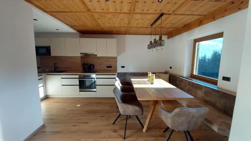 cocina con mesa de madera y sillas en Gästehaus Christoph, en Ried im Zillertal