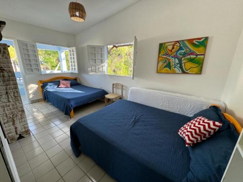1 dormitorio con 2 camas y 2 ventanas en Casa Maragogi, Ponta de Mangue - AL, en Maragogi