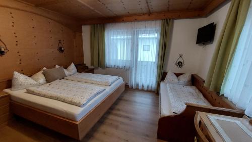 a bedroom with two beds and a window at Gästehaus Christoph in Ried im Zillertal