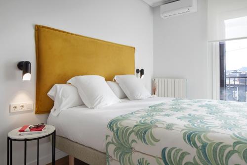 a bedroom with a large white bed and a window at Eki Terrace by FeelFree Rentals in Donostia-San Sebastián