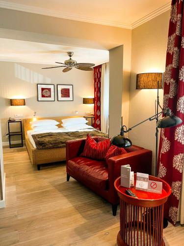a bedroom with a bed and a red couch at Hotel-Restaurant Schwanen in Metzingen