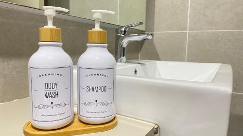 zwei Flaschen Waschmittel neben einem Waschbecken in der Unterkunft Bali Residence with Living Hall Melaka in Malakka