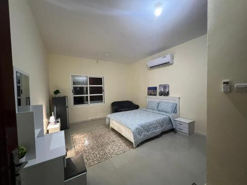 a bedroom with a bed and a television in it at Furnished Studio Apartment in Abu Dhabi