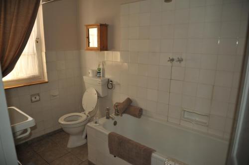 a bathroom with a toilet and a tub and a sink at Melton Wold Guest Farm in Meltonwold