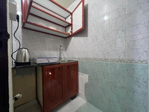 eine kleine Küche mit einer Spüle und einer Theke in der Unterkunft Furnished Studio Apartment in Abu Dhabi