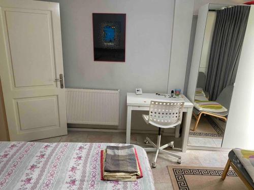 伊斯坦堡的住宿－Balat’ta huzurlu bir konaklama，一间卧室配有书桌、椅子和镜子