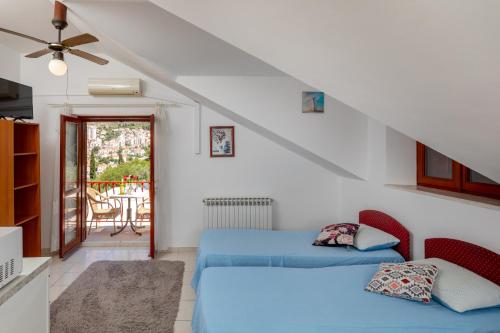 a living room with two beds and a balcony at Villa Valjalo in Dubrovnik