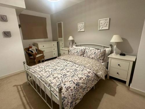 ein Schlafzimmer mit einem Bett, zwei Kommoden und einem Spiegel in der Unterkunft The Drake Apartment in Plymouth