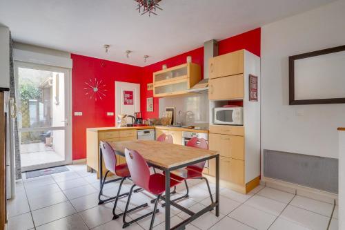 une cuisine avec des murs rouges et une table et des chaises dans l'établissement Charming townhouse with terrace, à Bordeaux