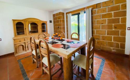 uma sala de jantar com uma mesa de madeira e cadeiras em Casa Las Animas Malinalco em Malinalco