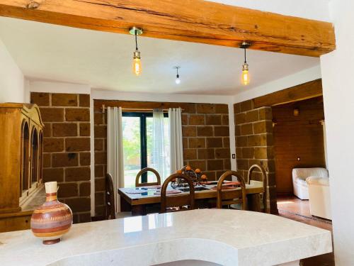 una cucina con tavolo e muro di mattoni di Casa Las Animas Malinalco a Malinalco