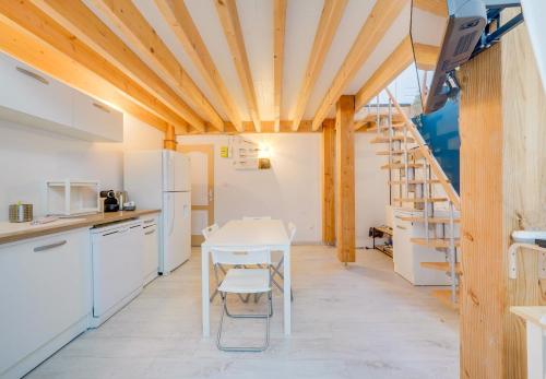- une cuisine avec des appareils blancs, une table et des chaises dans l'établissement Le Lafontaine - T3 Quartier Victoire, à Bordeaux